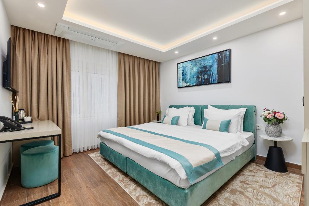 a hotel room with a large bed and a television at Hotel Splendido Bay in Tivat