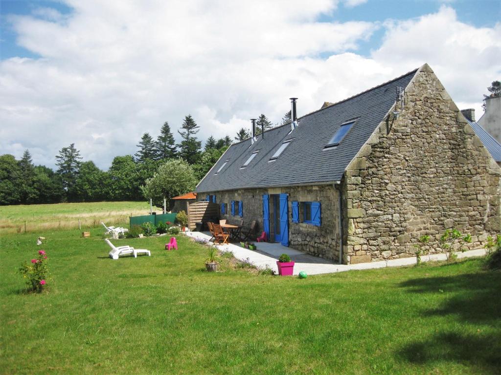 een stenen huis met blauwe deuren in een veld bij Le Domaine de Kerampape, gîte accessible, vignoble en Finistère sud in Pouldergat