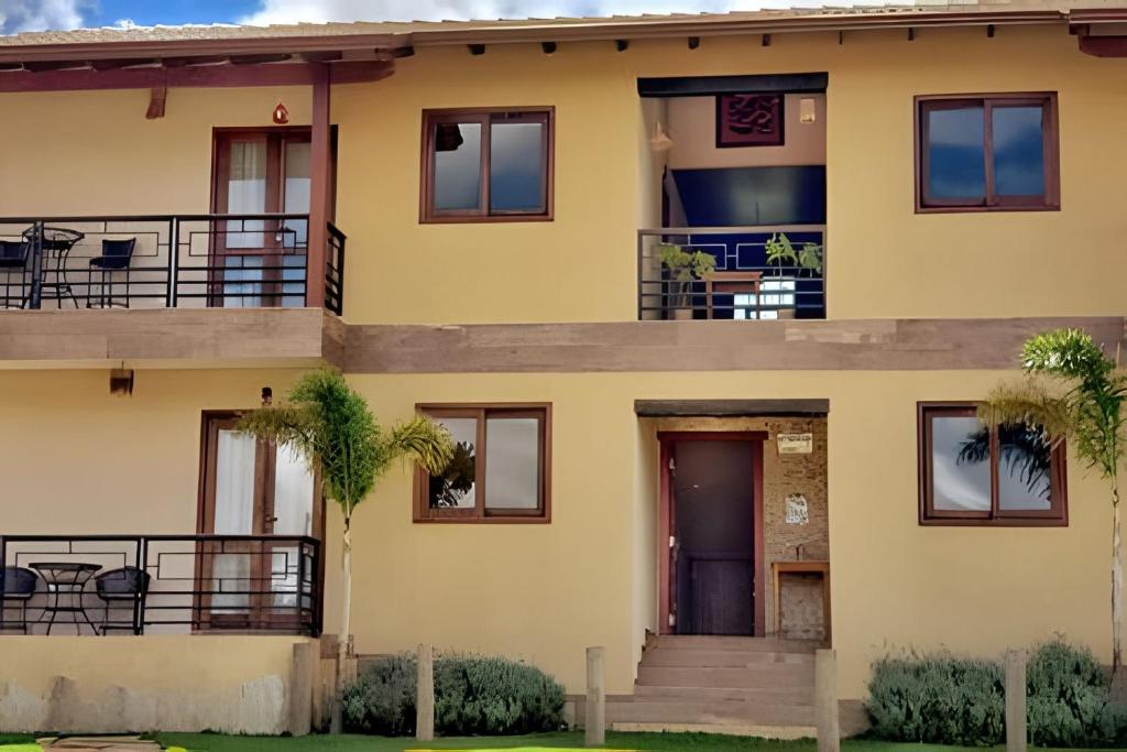 a yellow house with a balcony at Canto do Paraíso - Aluguel para Temporada in Alto Paraíso de Goiás