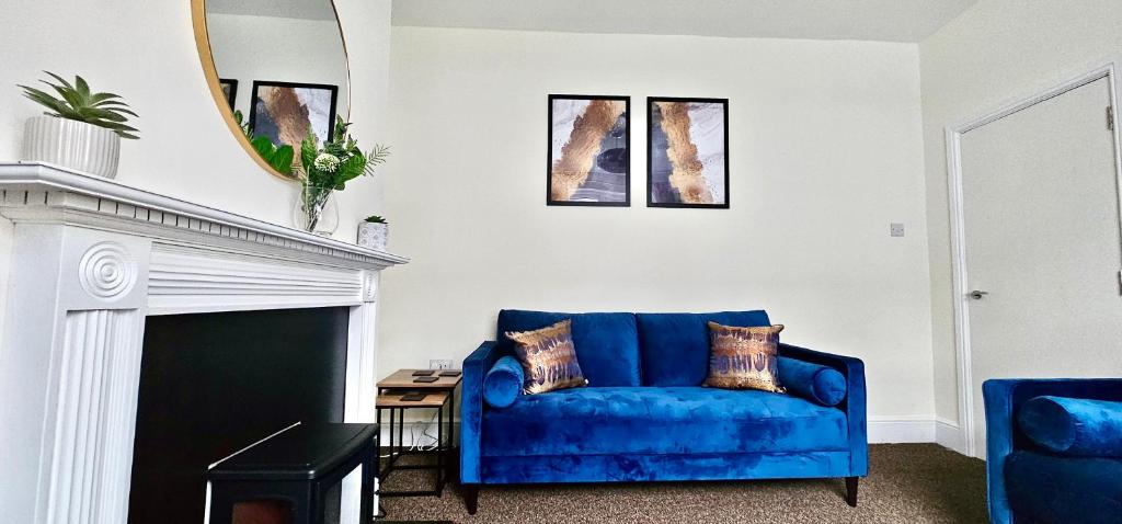 Sofá azul en la sala de estar con espejo en Bedford Street by Switchback Stays, en Cardiff