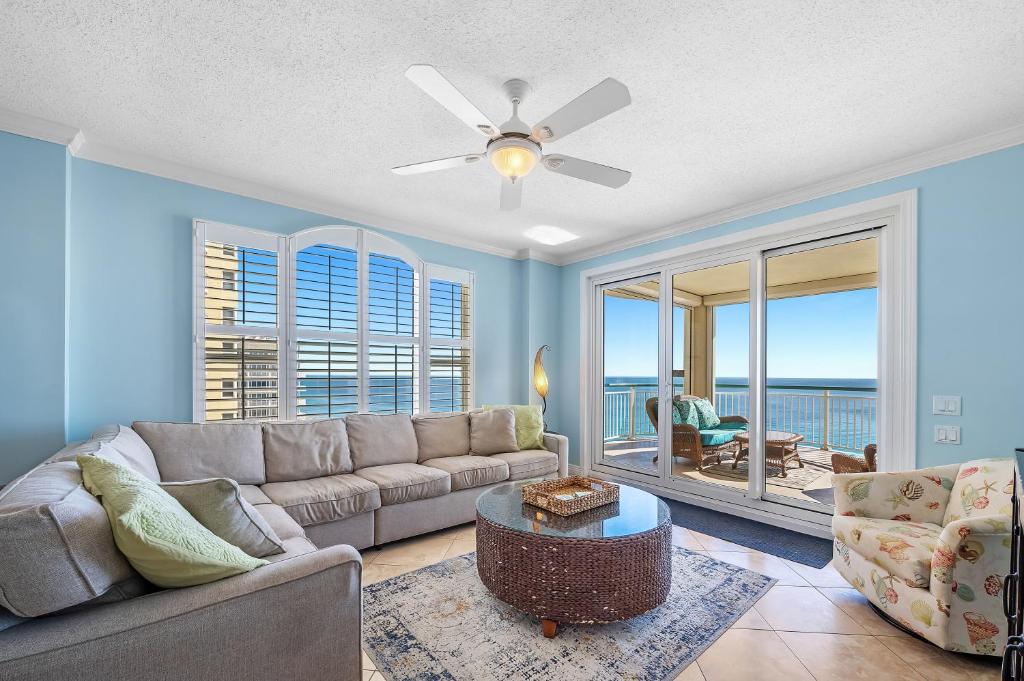 ein Wohnzimmer mit einer Couch und einem Deckenventilator in der Unterkunft Beach Colony Tower 14A in Pensacola