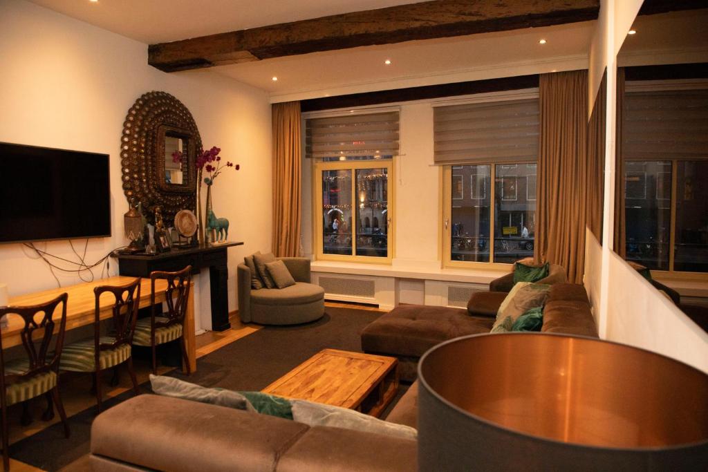 a living room with a couch and a table at Red light district B & B canal view in Amsterdam