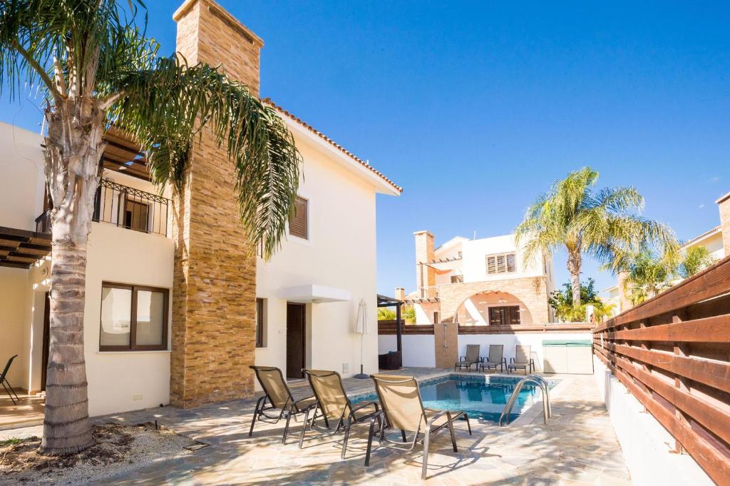 eine Terrasse mit Stühlen und einen Pool in einem Haus in der Unterkunft Villa Ioanna - 50m from Med Sea in Ayia Napa