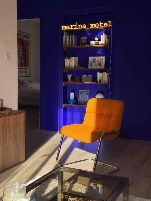een oranje stoel in een kamer met een blauwe muur bij Marina Motel in Marseille