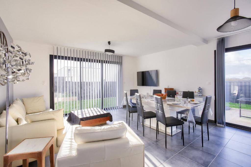 un salon avec un canapé et une table avec des chaises dans l'établissement Écrin de modernité à Saint-Alban, à Saint-Alban