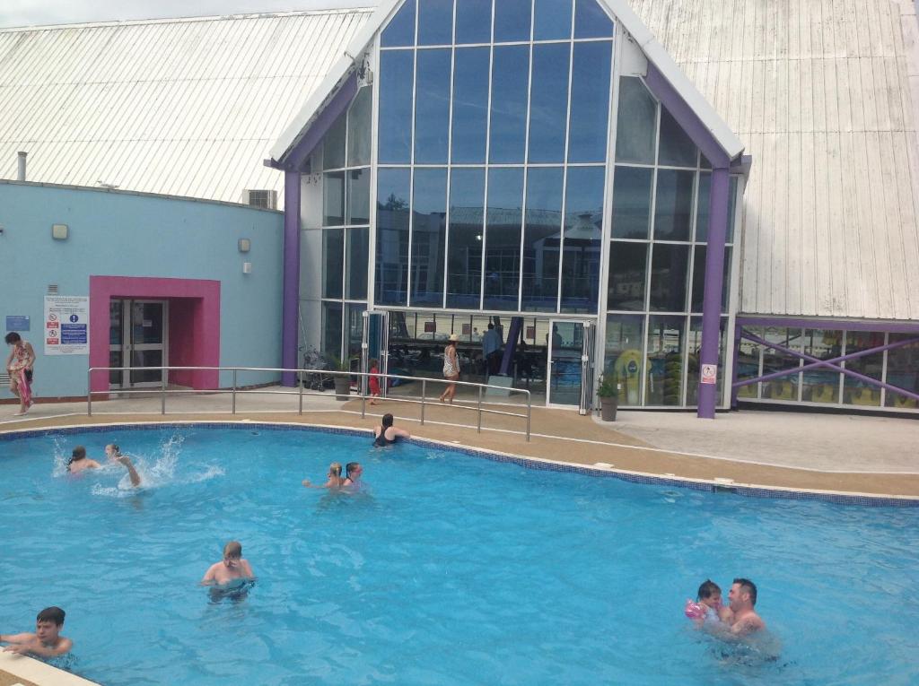 um grupo de pessoas numa piscina em frente a um edifício em Ritz Summerhouse em Hastings