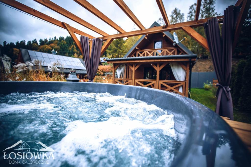 a hot tub in a backyard with a gazebo at Łosiówka in Bystre