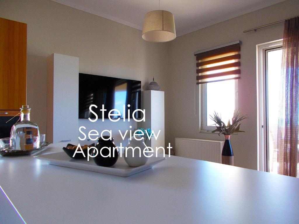 una cocina con una mesa con un cartel para una cita con vistas al mar en Stelia Apartment, en Ayiá