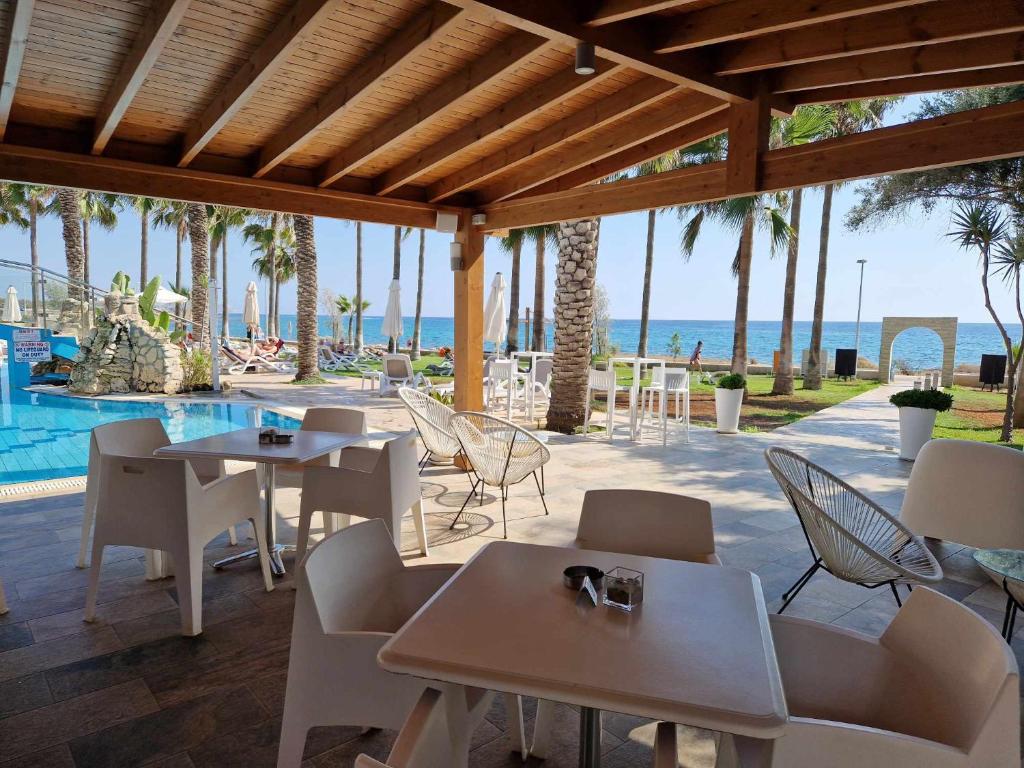 a patio with tables and chairs next to a pool at Simos Magic Beach Hotel Apts in Ayia Napa