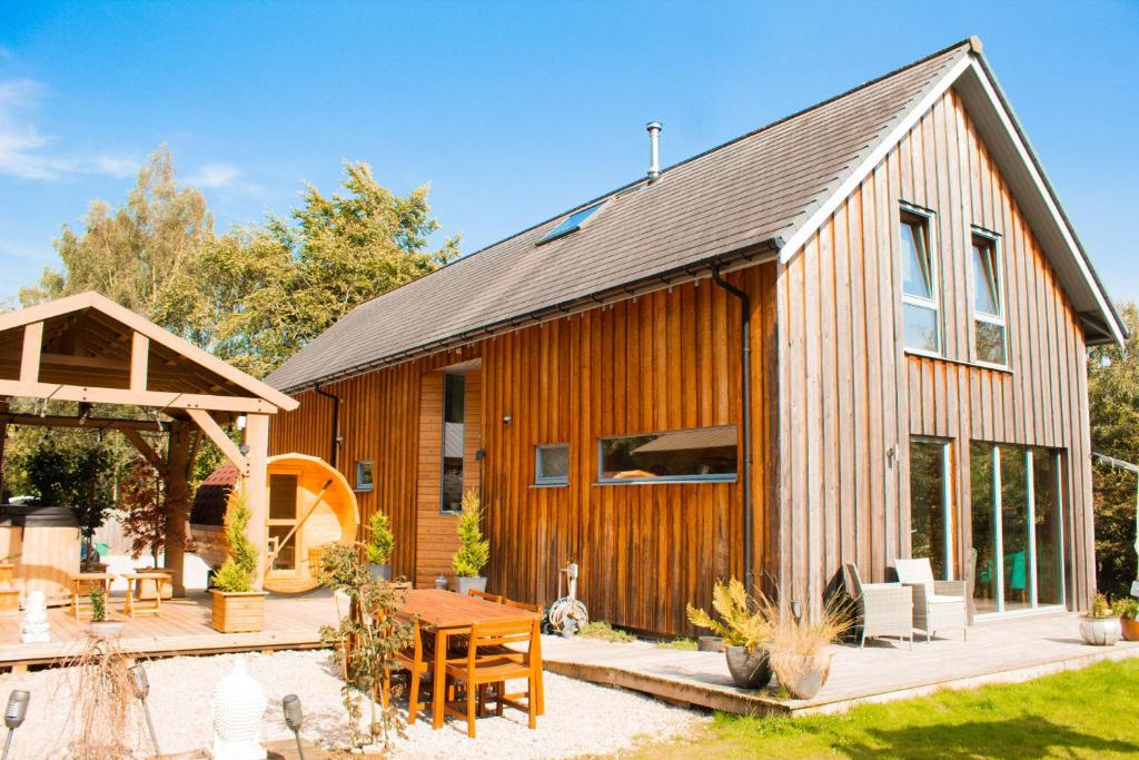 Casa de madera con patio y mesa en Woodhaus Aviemore Lodge en Aviemore