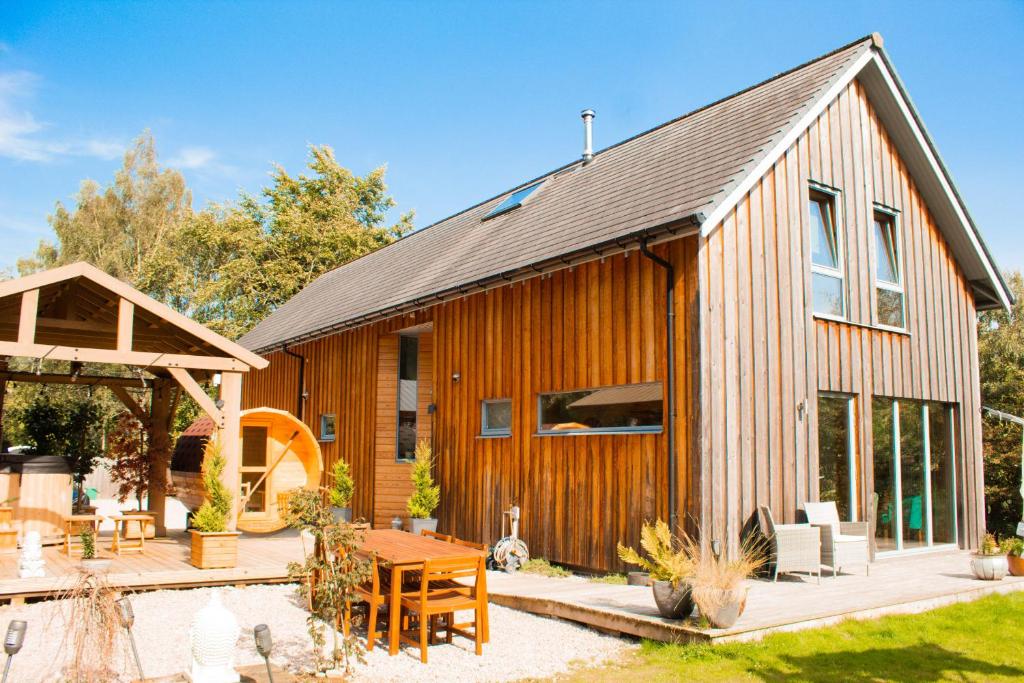 a wooden house with a patio and a table at Woodhaus Aviemore Lodge in Aviemore