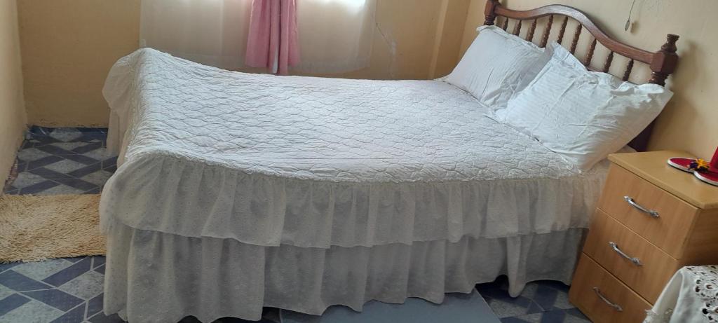 sypialnia z łóżkiem z drewnianym zagłówkiem w obiekcie Lk home w mieście Nanyuki