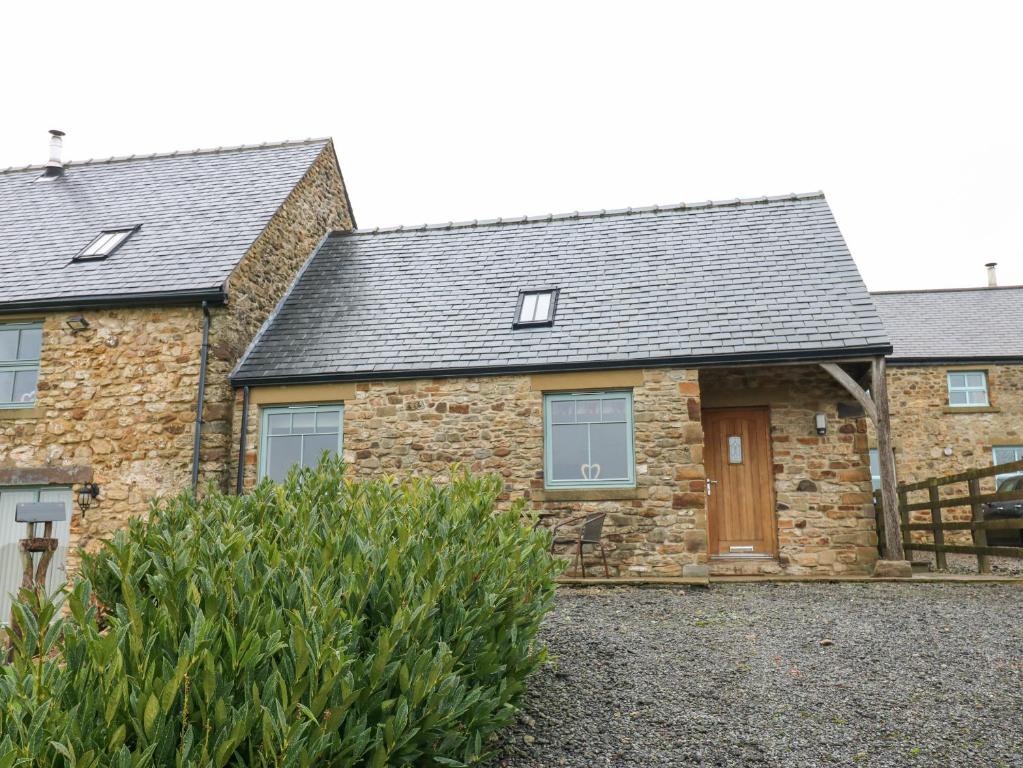 una casa de piedra con techo de pizarra en Sutton Newbold Cottage en Trimdon Grange