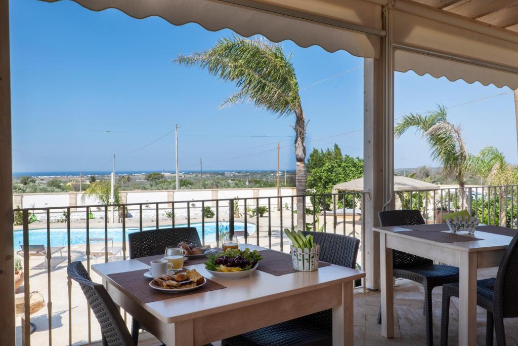 stół i krzesła na patio z widokiem na basen w obiekcie Arbor Exclusive B&B w mieście Ugento