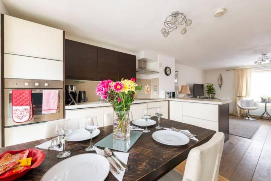 eine Küche mit einem Tisch und einer Blumenvase darauf in der Unterkunft Super Central beautiful 3 Bedroom in London