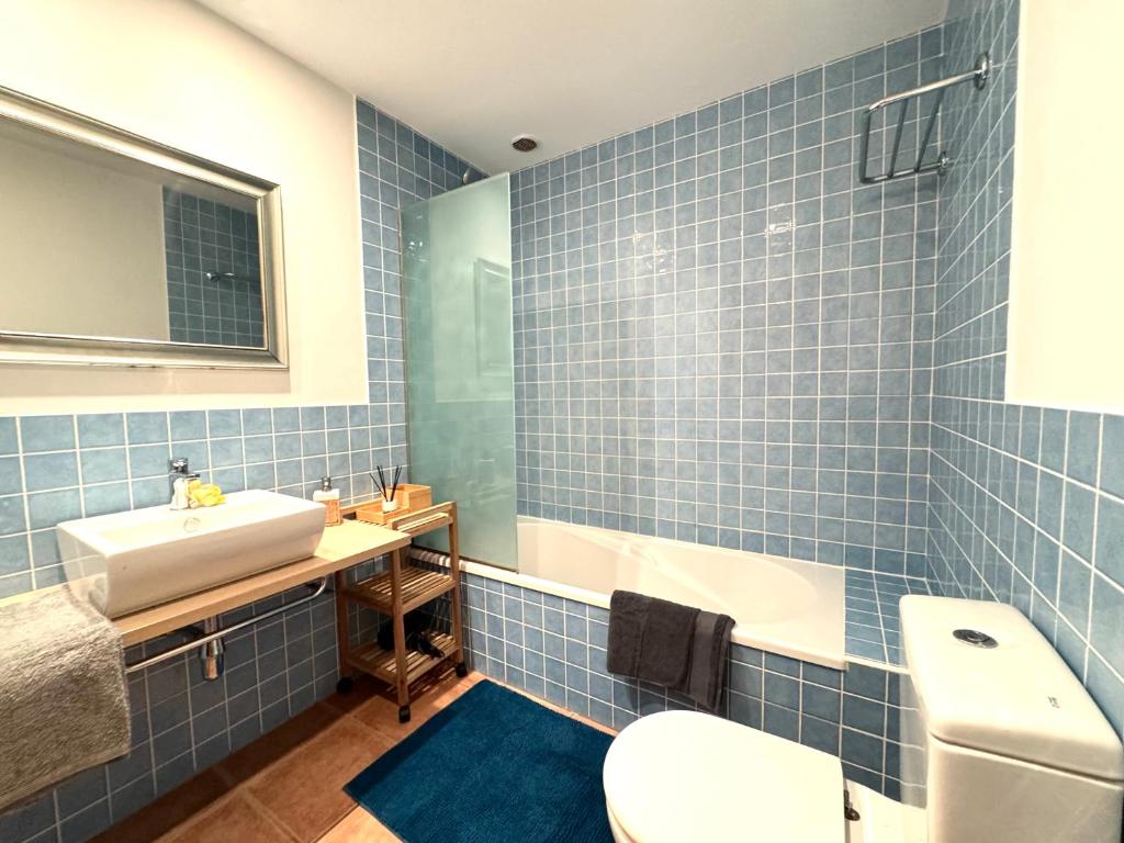 a blue tiled bathroom with a sink and a toilet at San Blas Golf del Sur Residence in San Miguel de Abona
