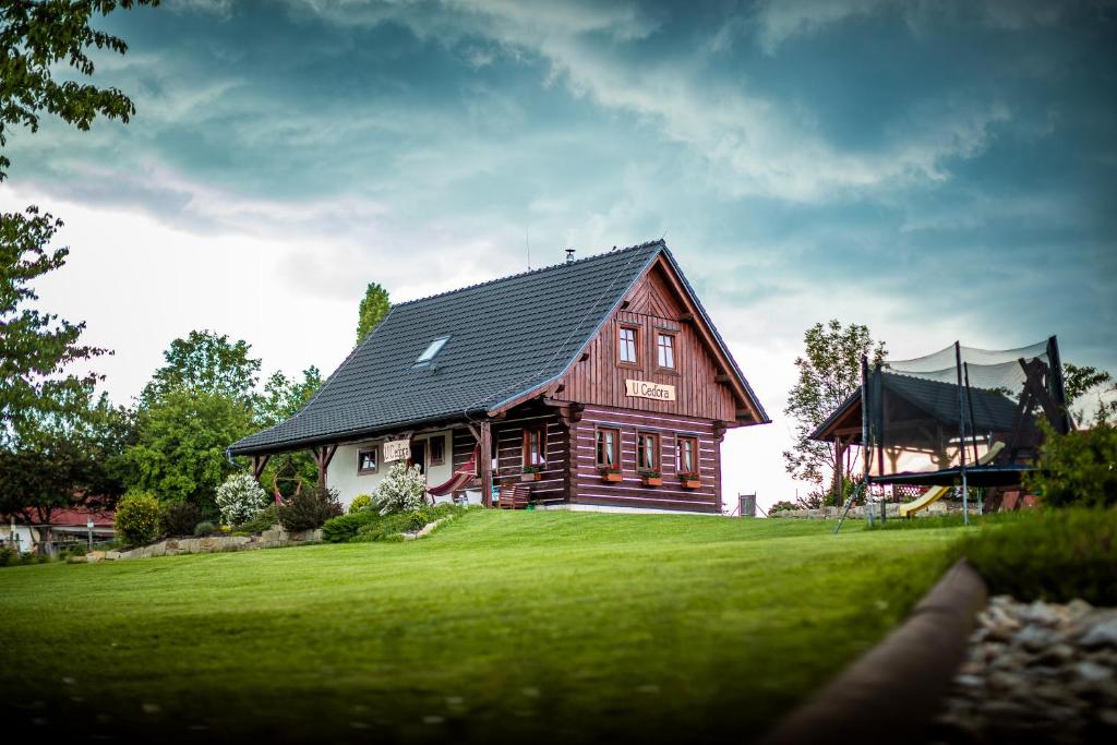a large wooden house on a green lawn at Chalupa U Ceďora in Petrovičky