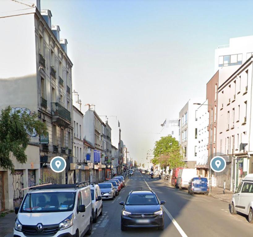 een straat met auto's aan de kant van de weg bij L'Industriel : Duplex Montreuil in Montreuil