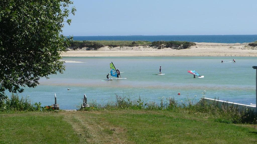 Un groupe de gens dans l'eau avec des cerfs-volants dans l'établissement Appartement vue sur mer, à Bénodet