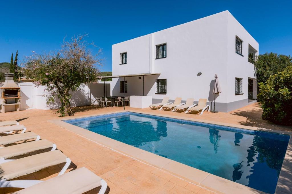 a villa with a swimming pool in front of a house at Villa Torres is a great villa only a 10 minute walk from the centre of Playa den Bossa in Ibiza Town