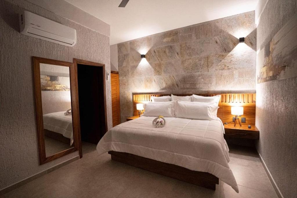 a bedroom with a large bed and a mirror at Sophie Hotel Boutique in Santa Cruz Huatulco