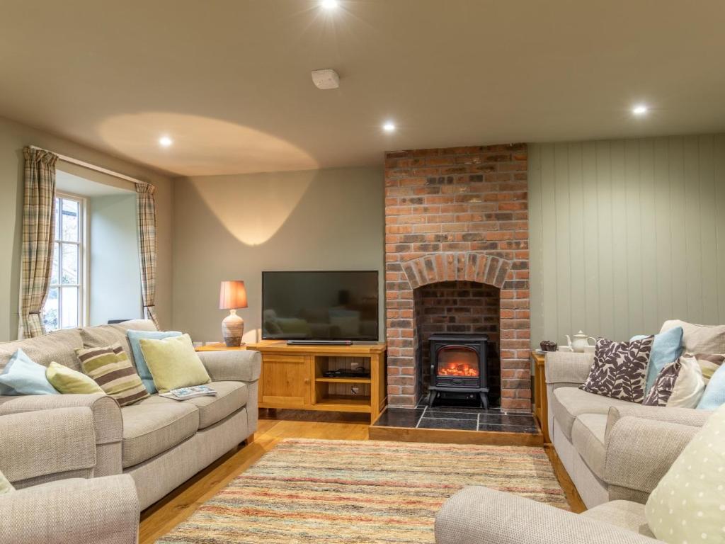a living room with two couches and a fireplace at 3 bed property in Axminster BLOCO in Axminster