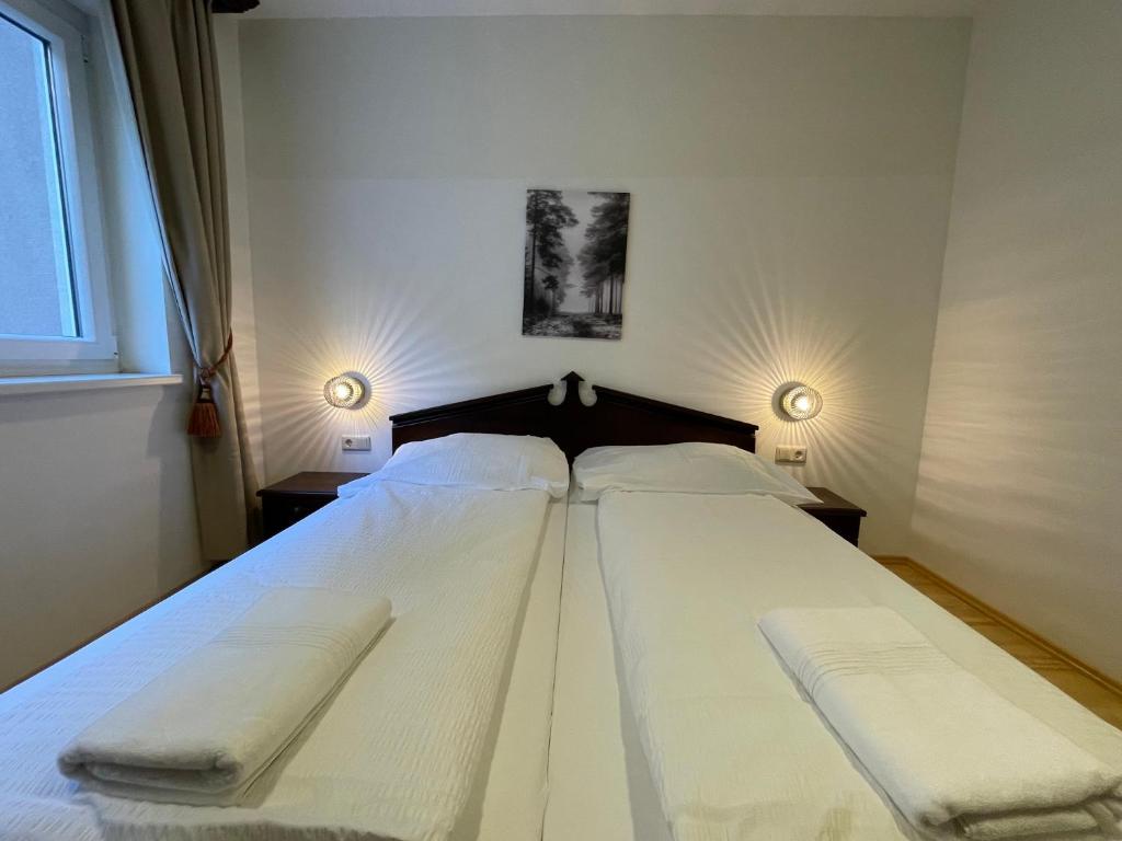 International House Sölden Standard Apartment ZW 10 في سولدن: سرير أبيض كبير في غرفة النوم مع مصباحين