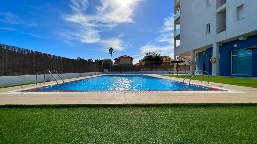 una piscina frente a un edificio en La Ribera - terraza, piscina y playa, en San Javier
