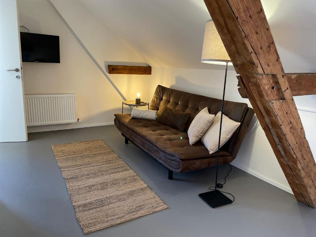 un soggiorno con divano marrone e lampada di Studio im Zentrum von Lochau, #3 a Lochau
