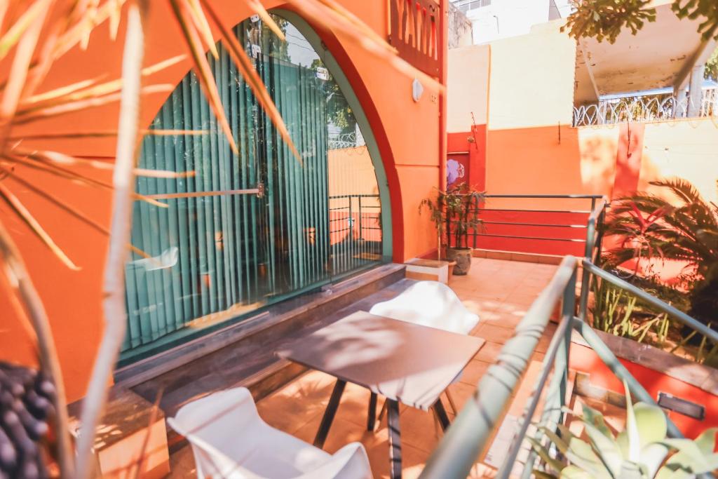 a balcony with white chairs and a building at Poente Hostel in Belo Horizonte