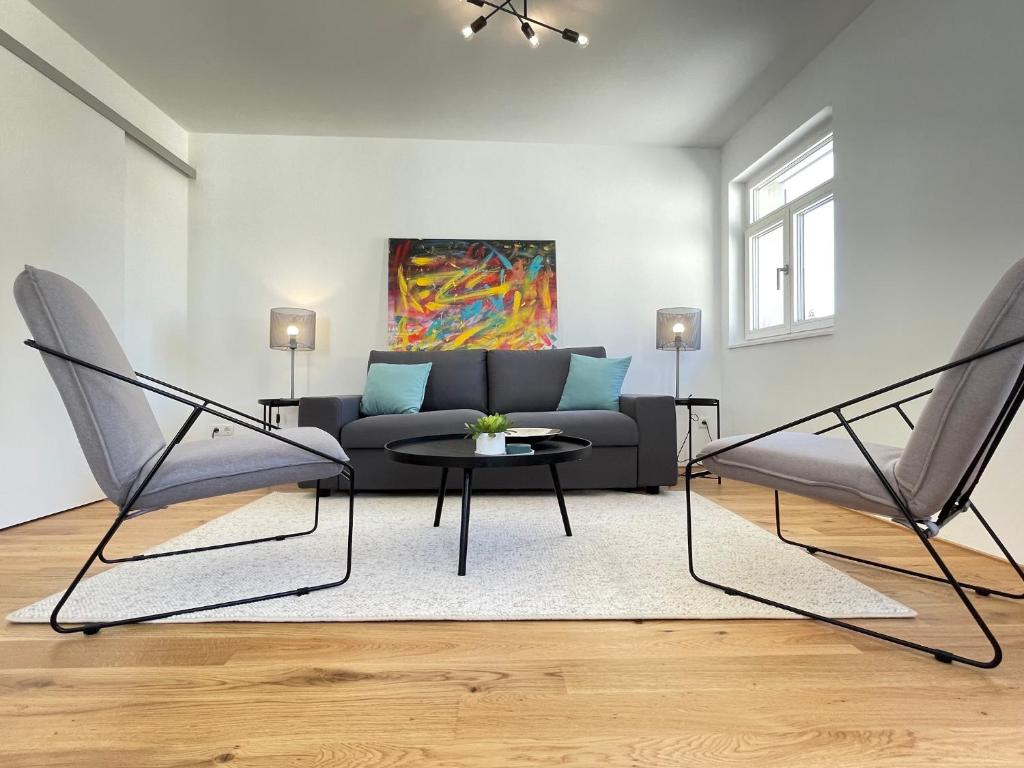 uma sala de estar com um sofá e uma mesa em VINCENT Apartment in Bregenz mit Parkplatz em Bregenz