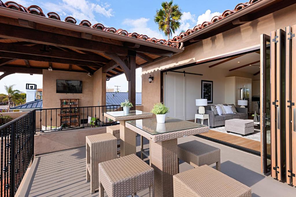 a patio with two tables and chairs on a balcony at Oceanview Rooftop Patio - Walk To The Beach & Park in Carlsbad