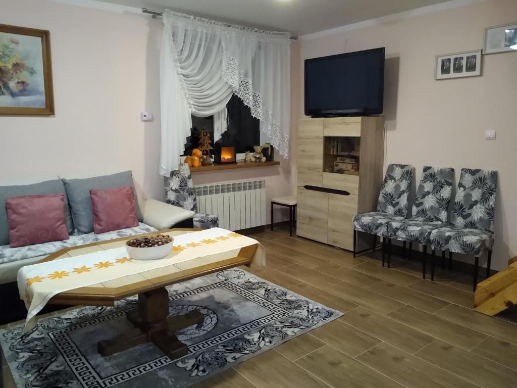 sala de estar con sofá y mesa en Domek Żegary, en Sejny