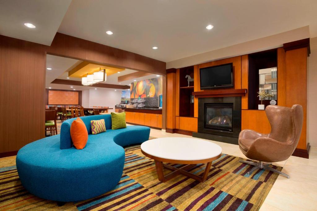 sala de estar con sofá azul y chimenea en Fairfield Inn & Suites Fort Worth University Drive en Fort Worth