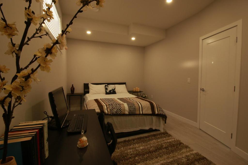 a bedroom with a bed and a desk with a computer at Feel at home in Chestermere in Chestermere