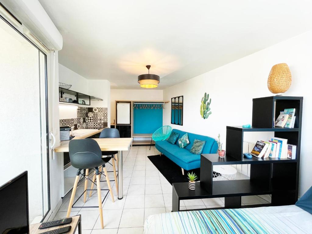 un salon avec un canapé bleu et une table dans l'établissement Lapin Blanc - Joli studio avec terrasse, à Marseille