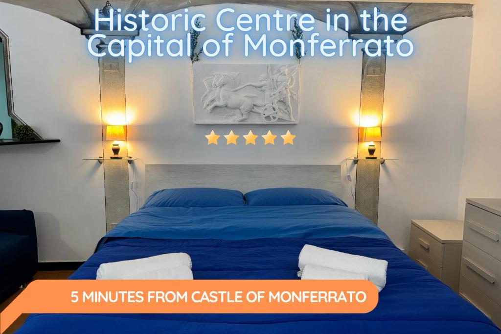a bedroom with a blue bed with two lights at Nel Pieno Centro Storico [Tutto a Due Passi] in Casale Monferrato