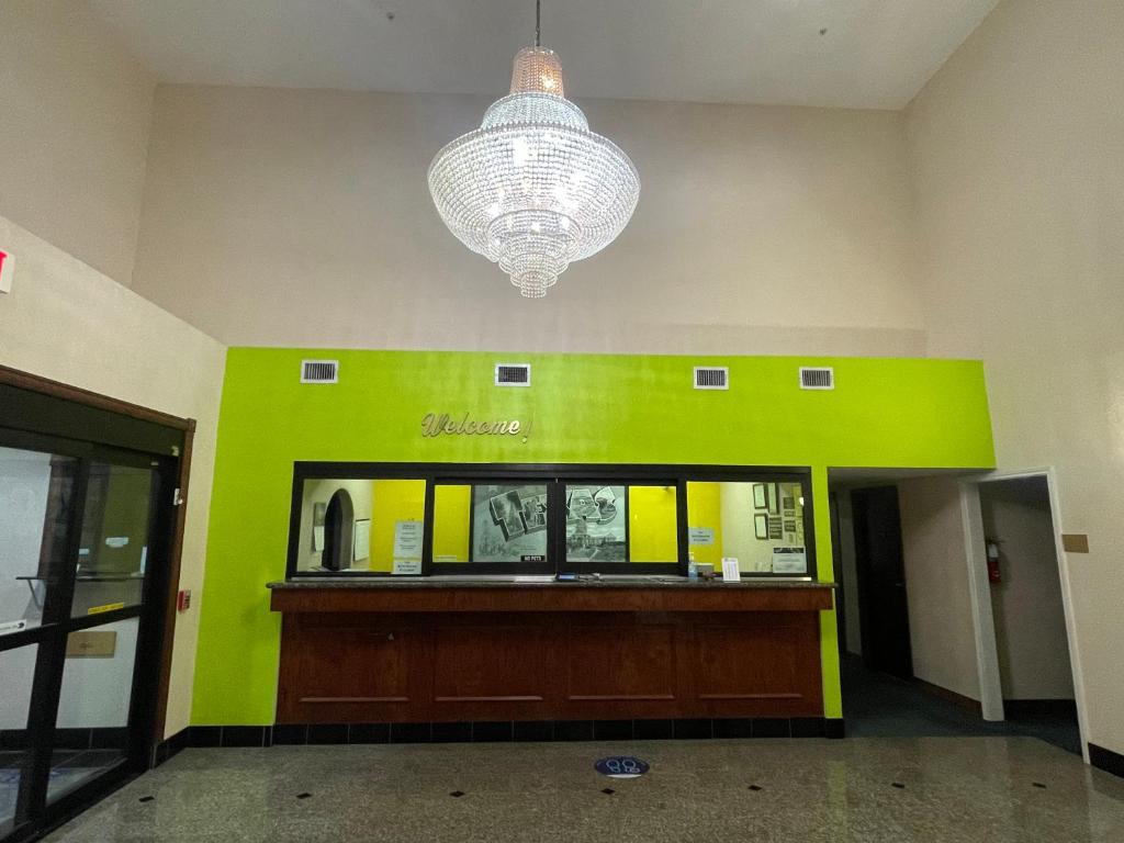 a lobby with a green wall and a chandelier at Belleza Inn & Suites Humble / FM 1960 in Humble