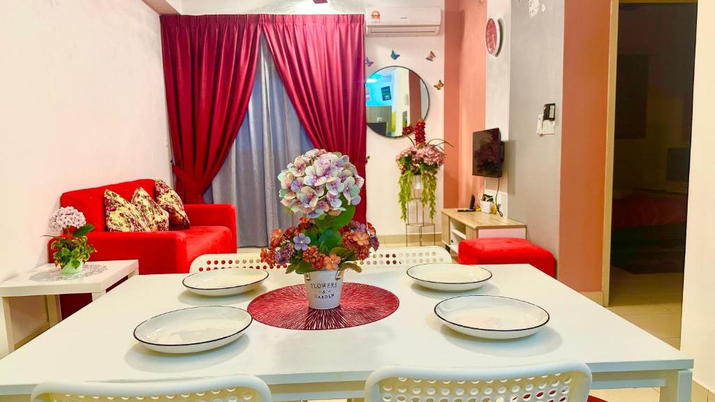 - un salon doté d'une table avec des assiettes et des fleurs dans l'établissement AF Homestay 3BR Near KLIA Free Wifi Netflix, à Sepang