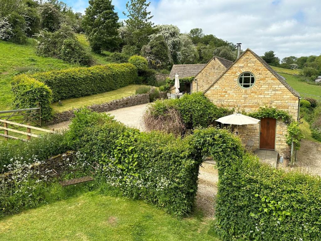 a house with a large hedge around it at 1 bed in Stow-on-the-Wold 52145 in Naunton