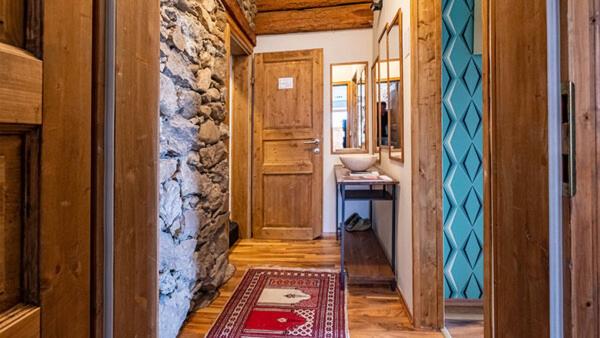 a hallway of a house with a stone wall at Art-Lodge Kunstpension in Afritz