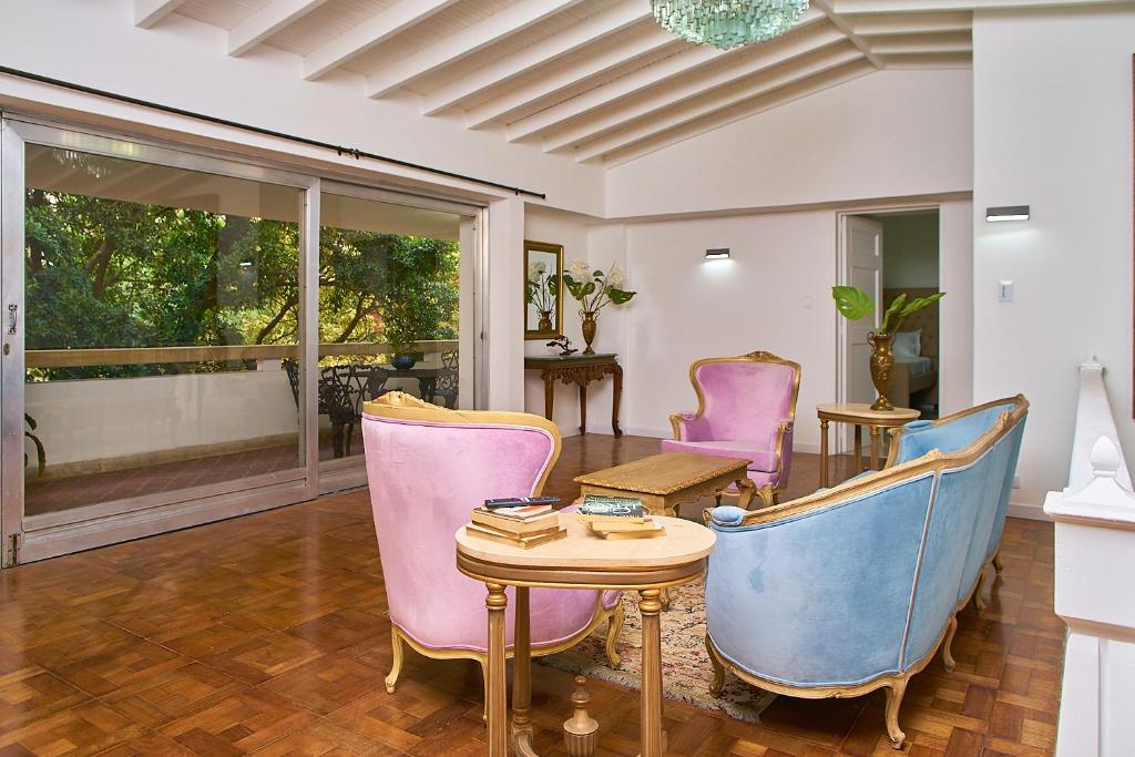 麥德林的住宿－Apartahotel Fiorentina Boutique，客厅配有椅子和桌子