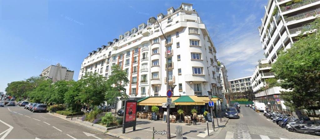 un grand bâtiment blanc dans une rue de la ville avec un bâtiment dans l'établissement Paris Jardin des plantes, à Paris