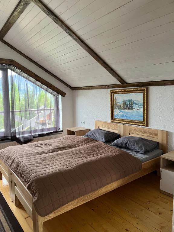 a large bed in a room with a large window at Готельно-Ресторанний комплекс Кичера in Volovets