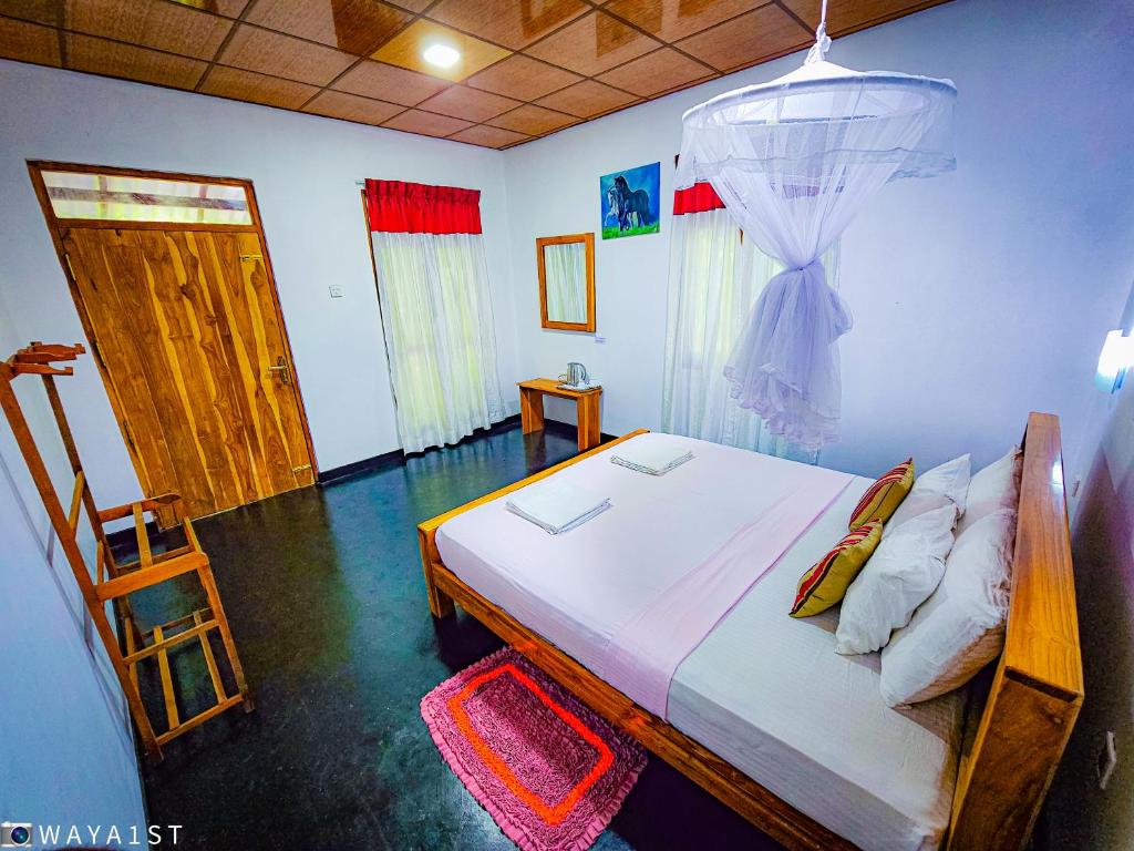 Schlafzimmer mit einem Bett mit Moskitonetz in der Unterkunft Sunbird's Home in Udawalawe
