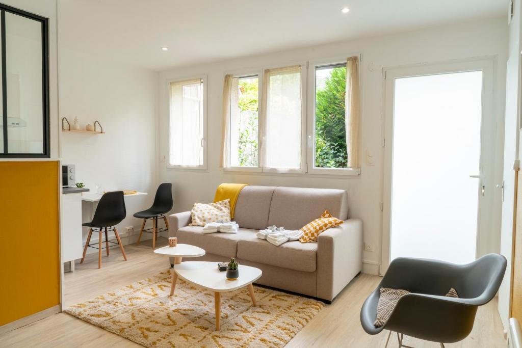 un salon avec un canapé et une table dans l'établissement STOCKHOLM- Studio Cosy et Patio, Proche Centre, à Charleville-Mézières