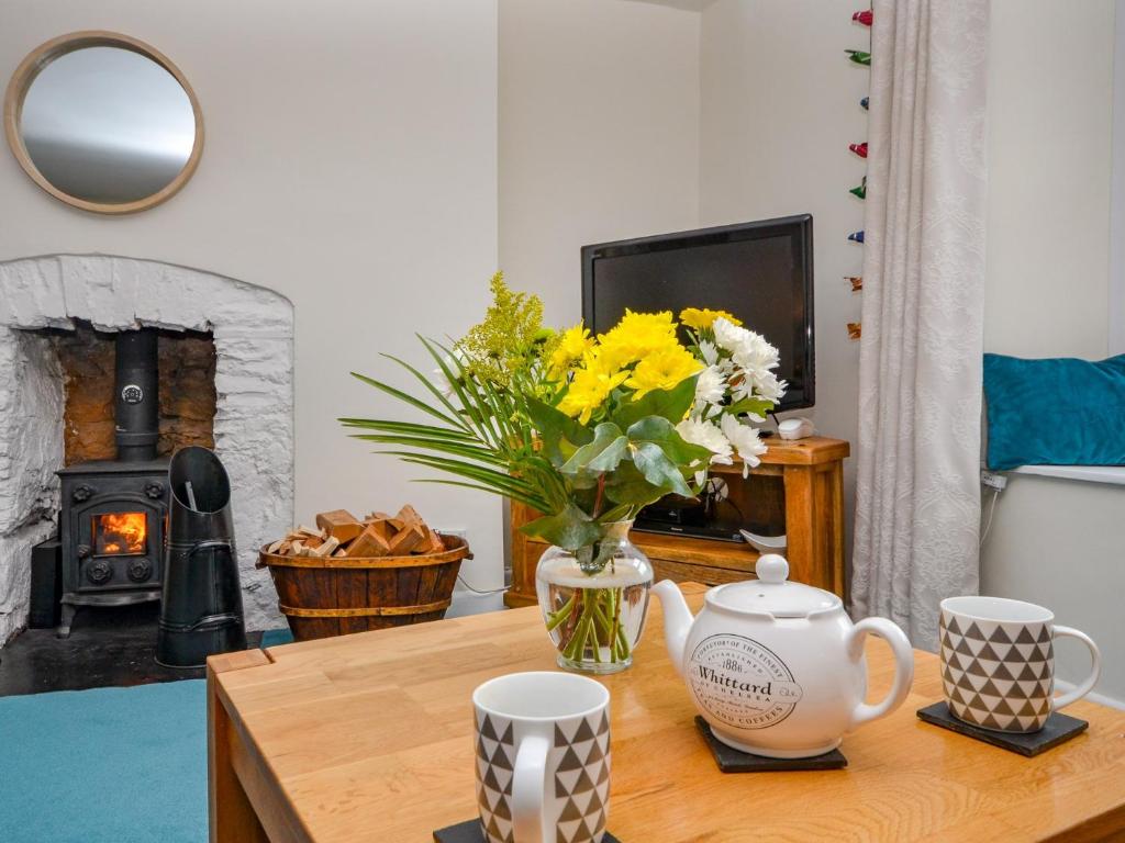 a living room with a table with a vase of flowers at 2 bed in Brixham 77769 in Brixham