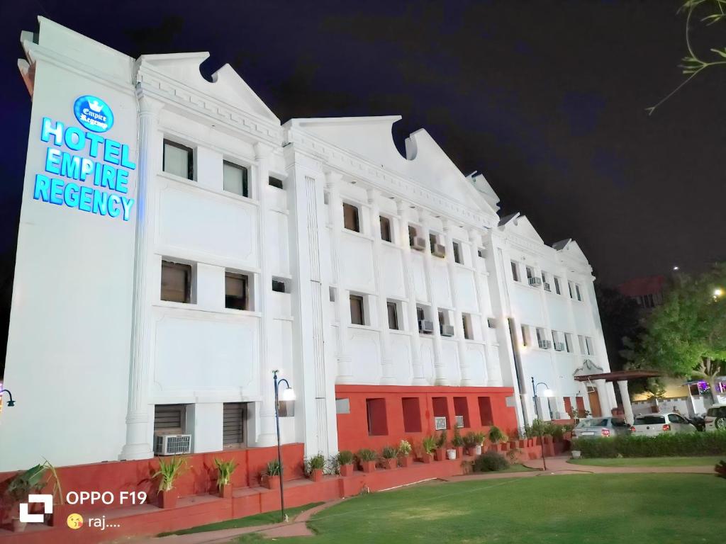 un edificio blanco con un hotel llega señal de piedad en él en Hotel Empire Regency en Jaipur