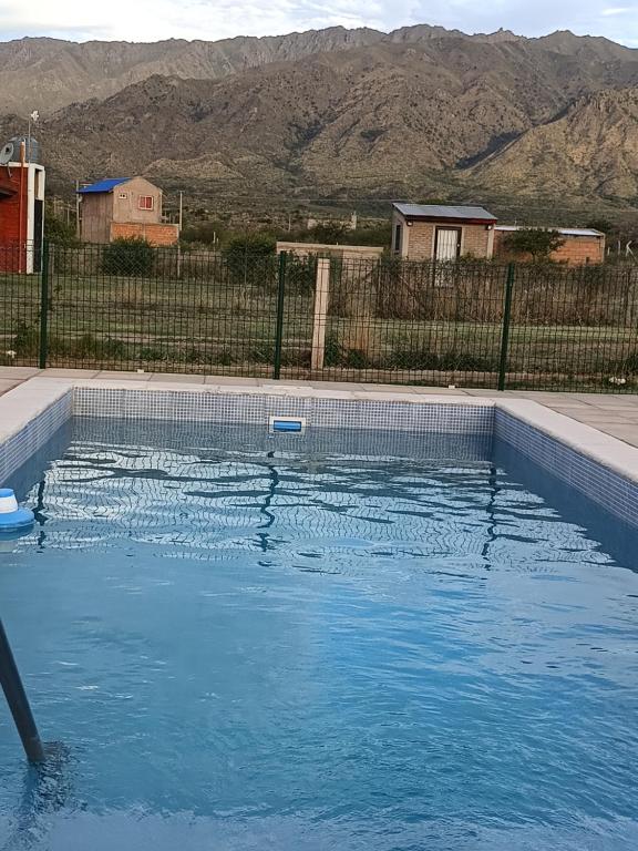 een zwembad van blauw water met bergen op de achtergrond bij Las Madreselvas in Villa de la Quebrada