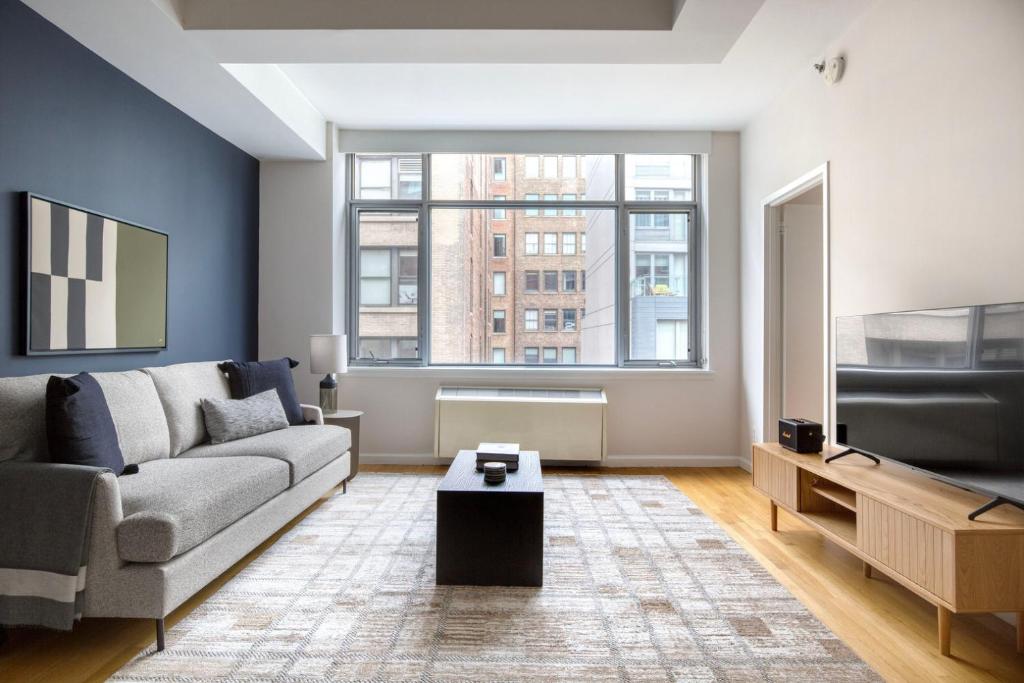 a living room with a couch and a flat screen tv at Chelsea 1br w gym doorman nr High Line NYC-1123 in New York